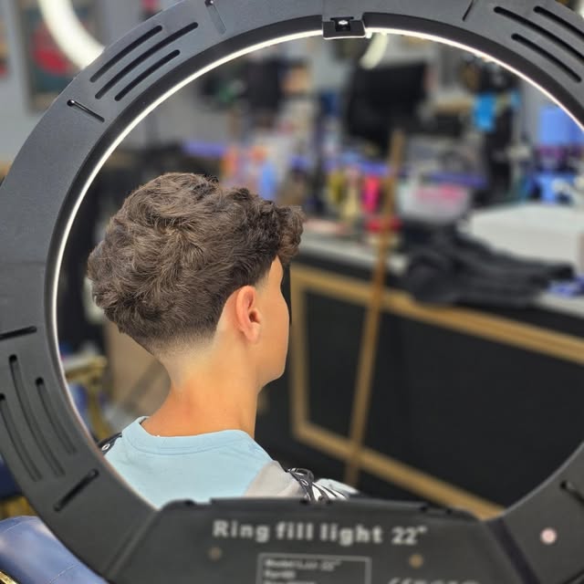 Curly haircut with a soft tapered finish by Seven17
